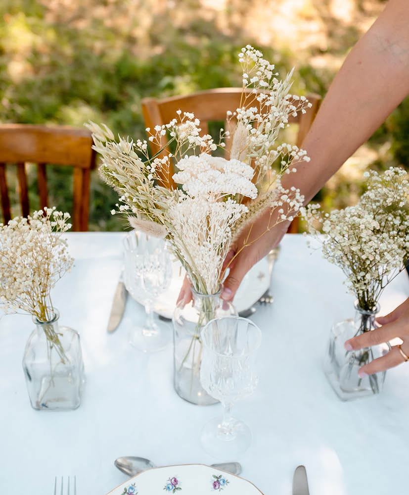 Personne qui pose un centre de table en fleurs séchées Rosa Cadaqués