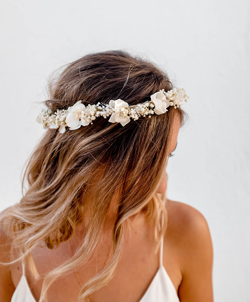 Femme blonde qui porte une couronne de fleurs séchées blanches de chez rosa cadaqués