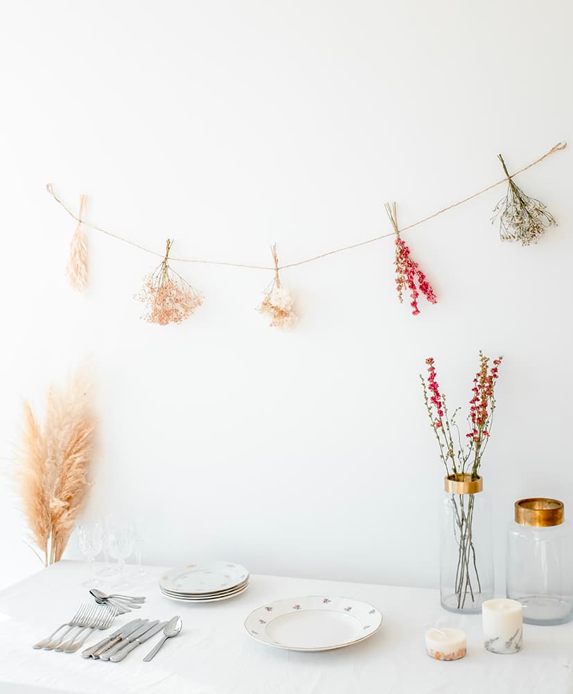 Guirlande en fleurs séchées Rosa cadaques Guirlande en fleurs séchées disposée contre un mur