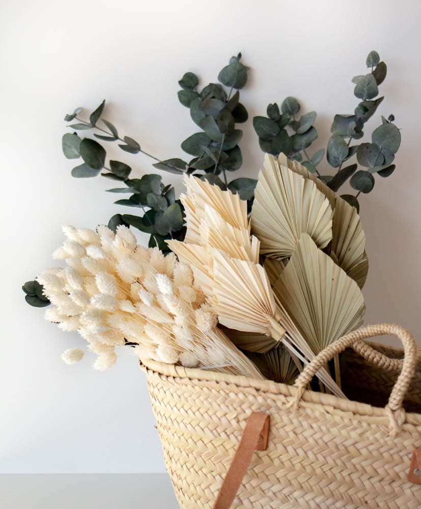 panier en osier remplit de bottes de fleurs séchées