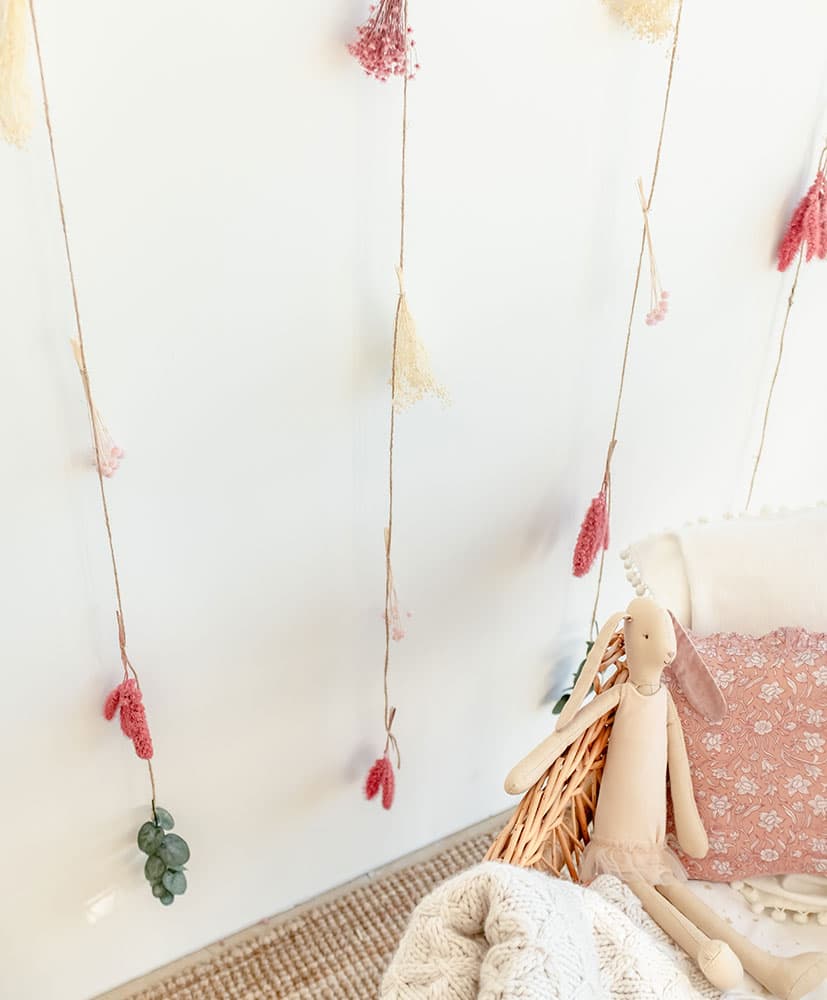 rideau de fleurs séchées dans les tons roses utilisé en tête de lit pour les enfants