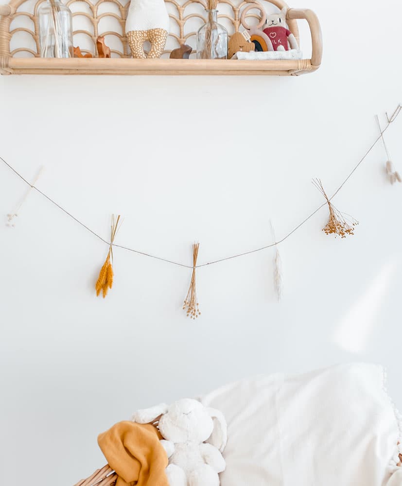 Guirlande de fleurs séchées dans les tons moutarde accrochée en tête d élit pour décoration chambre d'enfants