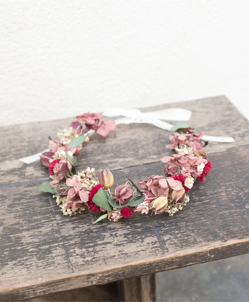 couronne de fleurs séchées posée sur un blanc en bois